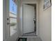 Front entry with white door and sidelight, leading into a sunroom at 409 Rose Croft Ter, The Villages, FL 32162