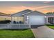 Tan house with white picket fence, one car garage, and nicely landscaped lawn at 409 Rose Croft Ter, The Villages, FL 32162