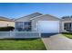 Tan house with white picket fence and two-car garage at 409 Rose Croft Ter, The Villages, FL 32162