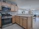 Well-equipped kitchen with stainless steel appliances and light wood cabinets at 409 Rose Croft Ter, The Villages, FL 32162