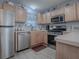 Galley style kitchen with stainless steel appliances and light wood cabinets at 409 Rose Croft Ter, The Villages, FL 32162