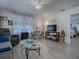 Living room with gray couch and glass coffee table, TV and entertainment center at 409 Rose Croft Ter, The Villages, FL 32162