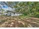 White house exterior with a large backyard and mature trees at 4626 Ne 7Th St, Ocala, FL 34470