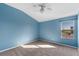 Bright bedroom with large window, neutral wall color, and ceiling fan at 561 Juniper Springs Dr, Groveland, FL 34736