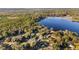 Aerial view of lakefront property with multiple buildings and lush trees at 10285 Ne 218Th Lane Rd, Fort Mc Coy, FL 32134