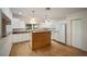 Bright kitchen featuring white cabinets, an island, and wood flooring at 10285 Ne 218Th Lane Rd, Fort Mc Coy, FL 32134