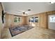 Spacious living room featuring wood paneling, tile floors, and a ceiling fan at 10285 Ne 218Th Lane Rd, Fort Mc Coy, FL 32134