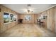 Living area with wood paneling, tile floors, and kitchen access at 10285 Ne 218Th Lane Rd, Fort Mc Coy, FL 32134