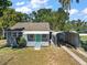 Charming single story home with gray siding and teal door, carport, and well-maintained lawn at 105 W Stevens Ave, Eustis, FL 32726