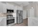 Stainless steel appliances and white cabinetry in kitchen at 1303 De La Garza Pl, The Villages, FL 32162