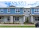 Two-story townhome with light blue exterior, stone accents, and landscaping at 13245 Peaceful Melody Dr, Winter Garden, FL 34787