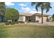 Well-maintained house with lush landscaping and a palm tree at 13437 Se 86Th Cir, Summerfield, FL 34491