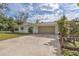 White brick ranch house with attached garage and landscaped yard at 13724 Country Club Dr, Tavares, FL 32778