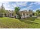 White house with green lawn and chain link fence at 13724 Country Club Dr, Tavares, FL 32778