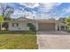 White brick ranch house with attached garage and landscaped yard at 13724 Country Club Dr, Tavares, FL 32778