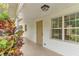 Front porch with light fixture and potted plants at 13724 Country Club Dr, Tavares, FL 32778