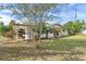 Side view of a single-story house with a yard at 13724 Country Club Dr, Tavares, FL 32778