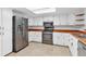 Kitchen with wood countertops, stainless steel appliances, and white cabinets at 13724 Country Club Dr, Tavares, FL 32778