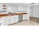 White kitchen with wood countertops and stainless steel appliances at 13724 Country Club Dr, Tavares, FL 32778