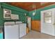 Interior laundry room with washer, dryer, and storage shelves at 13724 Country Club Dr, Tavares, FL 32778