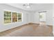 Living room with large window, neutral carpeting, and access to backyard at 13724 Country Club Dr, Tavares, FL 32778