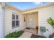 Front entrance of a yellow house with white door and lush landscaping at 1405 Conchas Dr, The Villages, FL 32162