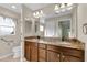 Double vanity bathroom with granite countertop and large mirror at 1494 Walnut Way, The Villages, FL 32163