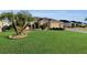 One story home with a palm tree and manicured lawn at 1494 Walnut Way, The Villages, FL 32163