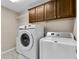 Laundry room with washer, dryer, and additional storage at 1494 Walnut Way, The Villages, FL 32163