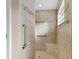 Walk-in shower with grab bars and tiled walls at 1494 Walnut Way, The Villages, FL 32163