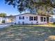 White single story home with carport, landscaping, and a spacious yard at 1611 Cherry Hill Rd, The Villages, FL 32159