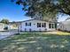 White single story home with carport, landscaping, and a spacious yard at 1611 Cherry Hill Rd, The Villages, FL 32159