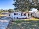 White single story home with carport, landscaping, and a paved driveway at 1611 Cherry Hill Rd, The Villages, FL 32159