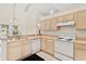 Bright kitchen with light wood cabinets and white appliances at 19010 County Road 42, Altoona, FL 32702