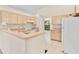 Bright kitchen with light wood cabinets, white appliances, and a breakfast bar at 19010 County Road 42, Altoona, FL 32702