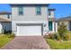 Two-story house with gray siding, white garage door, and landscaping at 30224 Armenia Rd, Leesburg, FL 34748