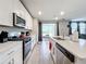 Modern kitchen with stainless steel appliances and an island with a breakfast bar at 30224 Armenia Rd, Leesburg, FL 34748
