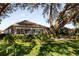 House exterior view showcasing landscaping and large oak trees at 3240 Hampton Ln, The Villages, FL 32162