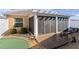 Backyard with covered patio, wooden deck, putting green, and a white fence at 3554 Marianna Pl, The Villages, FL 32163