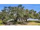 House nestled amongst large oak trees near the water at 38230 Yale Cir, Leesburg, FL 34788