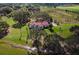 Aerial view of a home on the lake surrounded by trees at 38230 Yale Cir, Leesburg, FL 34788