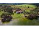 Aerial view of a home on a lake with surrounding farmland at 38230 Yale Cir, Leesburg, FL 34788