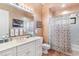 Bathroom with white vanity, shower/tub combo, and floral shower curtain at 38230 Yale Cir, Leesburg, FL 34788