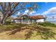 White one-story home with brown tile roof, under large oak tree, near water at 38230 Yale Cir, Leesburg, FL 34788