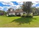 One-story home's side view, showcasing lawn and trees at 38230 Yale Cir, Leesburg, FL 34788