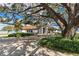 Front view of house featuring landscaping and a large oak tree at 38230 Yale Cir, Leesburg, FL 34788