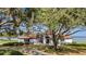 House exterior with large oak trees and water view at 38230 Yale Cir, Leesburg, FL 34788