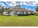 House exterior featuring Spanish tile roof and manicured lawn at 38230 Yale Cir, Leesburg, FL 34788