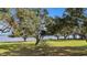 Expansive waterfront property with lush lawn and trees at 38230 Yale Cir, Leesburg, FL 34788
