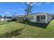 Backyard view of home with covered patio and green grass at 5047 Meadow Song Dr, Okahumpka, FL 34762